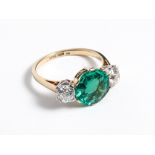 Ladies emerald and diamond ring set with a circular emerald of exceptional rich green colour and