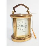 Miniature brass oval carriage clock by Mathew Norman of London.