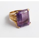 Large ladies amethyst dress ring set with a trap cut amethyst in a yellow mount tests as gold ring