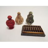 Three oriental snuff bottles and a miniature brass and onyx abacus