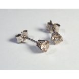 A pair of white gold diamond set stud earrings total diamond weight .