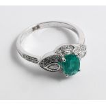 An 18ct gold emerald and diamond dress ring set with an oval emerald in an antique style setting