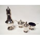 A 3 piece hallmarked silver cruet set with blue glass liners and spoons and a silver sugar shaker