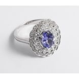 An 18ct white gold tanzanite and diamond cluster ring set with an oval tanzanite surrounded by 2