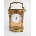 Carriage clock of shaped oval form with white enamel dial and blue numerals, with key.