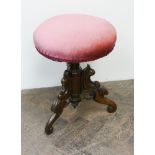 A Victorian mahogany adjustable circular piano stool with red upholstered seat