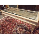 A long limed oak coffee table with inset glass top