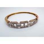 9ct yellow gold and diamond set bangle in Greek key motif, gross weight 12.