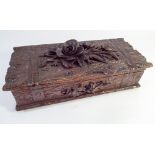 A Black Forest style carved wooden jewel or pen box carved with rose to the top