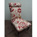 An Edwardian nursing chair upholstered in a red printed fabric