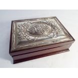 A rectangular jewellery box with hallmarked silver inset lid decorated with flowers 23cms across