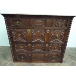 An antique oak chest of 4 long drawers with fielded panels and brass tear dropped handles 108cms