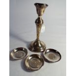 A hallmarked silver candlestick with fixed sconce and 3 white metal ashtrays inset with Mexican