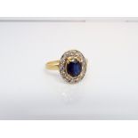 A French sapphire and diamond cluster ring set in an oval setting, unmarked yellow gold,