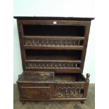 An antique carved oak kitchen plate rack with small cupboard to the base and bobbin turned lined