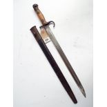 An old British bayonet complete with its leather scabbard and metal mounts,