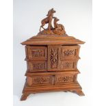 A Black Forest style cared wooden jewel box with deer mounts