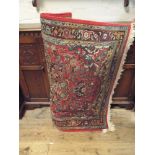 A red and patterned wool pile Persian design rug