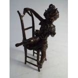 Contemporary green patinated bronze of young girl on chair teasing a cat - height 23cm tall