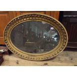 A Regency style oval mantle mirror with antiqued plate glass