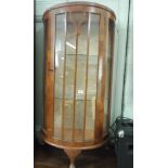 A bow front glass display cabinet