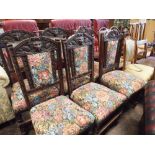 A set of 4 oak framed dining room chairs with lion masks in the backs with tapestry upholstered