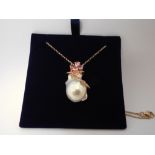 Unusual baroque pearl pendant with pink sapphire details set in 18ct rose gold with chain.