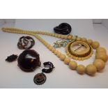 Row of early 20th century ivory graduated beads, circular tortoiseshell brooch,