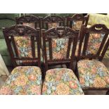 A set of 4 oak framed dining room chairs with lion masks in the backs with tapestry upholstered