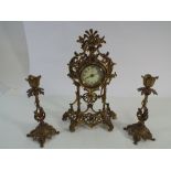 A late 19th century gilt brass clock garniture comprising clock and a pair candle sticks,