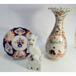 Blanc de chine figure of a temple lion, Imari plate and a oriental vase with flared rim,