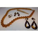 A row of Baltic amber beads, tortoiseshell earrings,