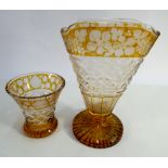 Two Bohemian amber glass etched cut glass vases on star cut bases tallest measuring 23cms