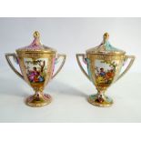 A pair of Dresden twin handled vases and covers decorated with 18th century style figurines within