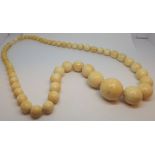 A row of 20th century graduated ivory beads largest bead diameter 2.