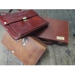 2 old brown leather suitcases and an old brown leather attache case