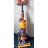A yellow and silver Dyson upright vacuum cleaner