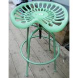 A green cast tractor seat stool