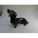 A Beswick fireside model of a black and tan Dachshund black printed mark on base,