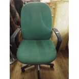 A revolving office elbow chair in green covering