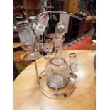 Etched glass wine decanter and six glasses on a leaf mounted plated stand