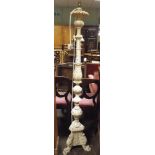 A decorative cream standard lamp on carved pillar and tri-pod base