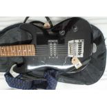 Six string Encore black and brown electric guitar with a blue and black strap in its black fabric