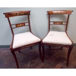 Set of six Regency rosewood brass inlaid dining chairs on sabre legs with cream upholstered seats.