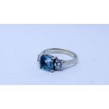 Aquamarine and diamond three stone ring set with a cushion cut aquamarine flanked each side with a