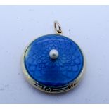 Edwardian circular gold locket the hinged lid decorated with engine turned blue enamel the centre