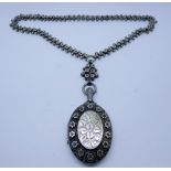 Victorian silver oval ornate locket on a fancy ling and ball chain,