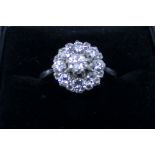 Diamond cluster ring set in a circular setting on unmarked 18ct white gold shank,