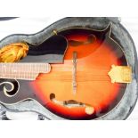 Vintage eight string black and orange mandolin in its black fitted case