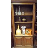 A 2'6 oak open bookcase with cupboards under